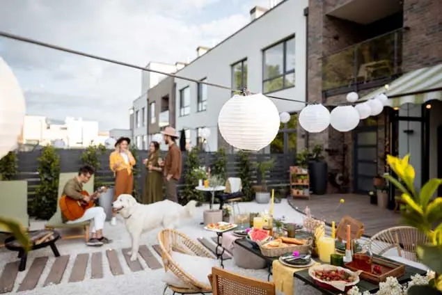 Chill-out corner on the terrace with décor for outdoor gatherings Chill-out area on a modern terrace with garlands, food, friends, and natural décor