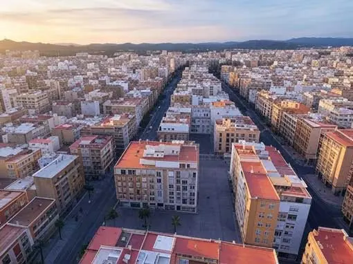 City of Castellón: panoramic view at sunset Aerial view of where to buy an apartment in Castellón, a city with residential buildings and mountains in the background