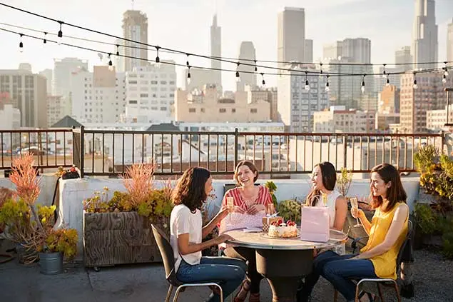 Stylish urban terrace decoration for gatherings with friends Group of women celebrating on an urban terrace decorated with garlands and seasonal plants