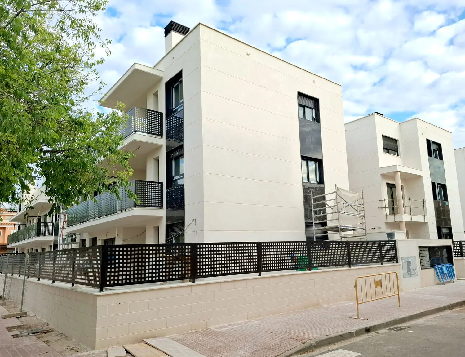 A Lledó Auditorium építési előrehaladása, befejezett homlokzattal és végső részletekkel Lledó Auditorium épület, előrehaladott építési munkák, modern fehér homlokzat és fém erkélyek