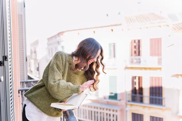 Properties in the centre of Castellón: comfort and style in your new home A happy woman holding a book, enjoying the natural light in a flat in the centre of Castellón